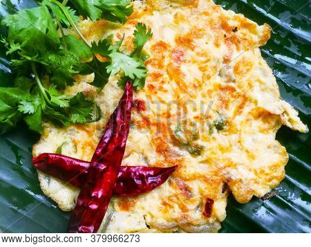 Omelette With Coriander Leaves And Red Chillies In A Banana Leaf.the Banana Leaf Has Green Color And