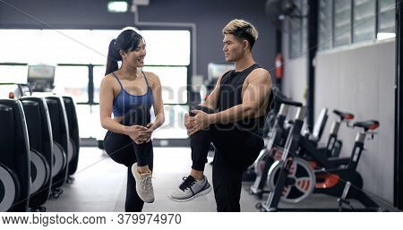 Healthy Two People Young Asian Doing Stretching Leg After Workout At Fitness Gym, Cooldown Muscle He