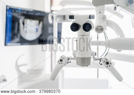 Interior Of Dental Practice Room With Close Up On Microscope And Dental Scan On The Display. Stomato