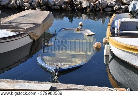 3 Old Fisherboats In Jetty, Middle One Sinking With Fish Swimming In Its Body