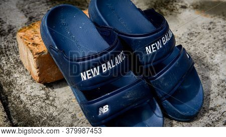 Close Up View A Pair Of Blue New Balance Flip Flops With Vintage Background.