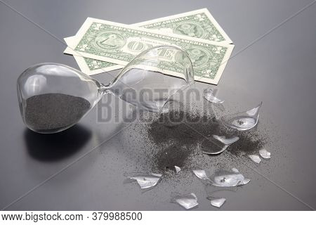 Broken Hourglass On The Background Of Banknotes. Loss Of Time And Finances. End Of Earning Opportuni