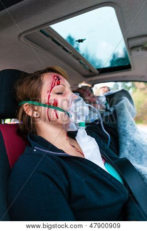 Nehoda - oběť v havarovaných vozidlech, dostává lékařské první pomoci od hasičů