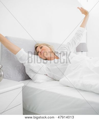 깨어난 금발 여자와 침대에 가정에서 stetching
