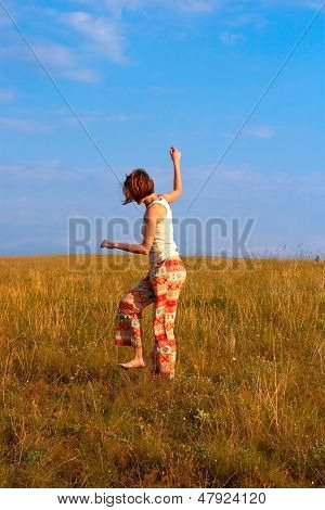 Bella donna danza a piedi nudi sul prato