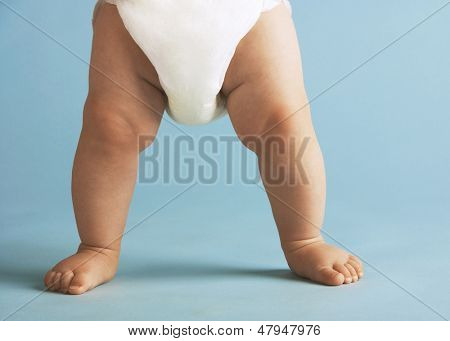 Erkek bebek bezi ayakta üzerinde mavi arka plan izole düşük bölümü