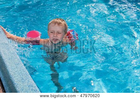 เด็กชาย Swims ในสระว่ายน้ำ