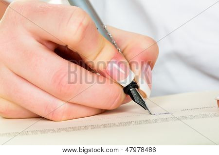 una donna firma un contratto o un testamento con una penna stilografica.