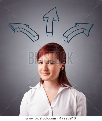 Schöne junge Dame, die mit Pfeilen overhead denken