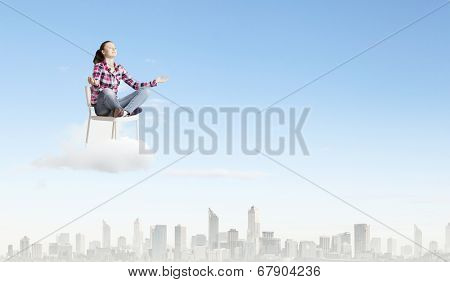 Young woman sitting on chair and meditating