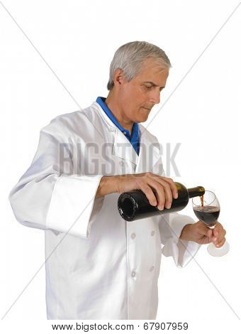 winemaker/enologist pouring red wine into a glass, to sample his work isolated on white.