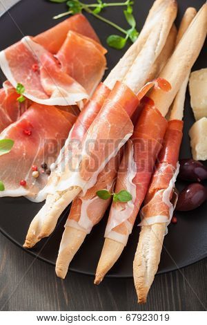 prosciutto ham and grissini bread sticks. italian antipasto 