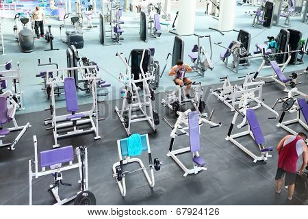 MOSCOW, RUSSIA - MAY 8, 2014: Sport hall of fitness center Gold Gym with traineger equipments. In Russia, Gold Gym opened in 1996.
