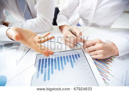 Close-up of female and male hands over business document in touchpad