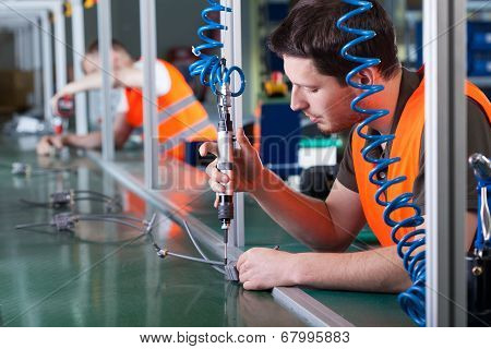 Men During Precision Work On Production Line