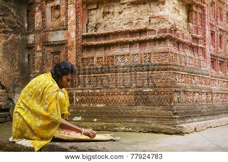 Woman sorts corn at Pancharatna Govinda temple Puthia, Bangladesh.