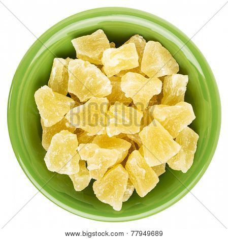 chunks of dried pineapple in an isolated green ceramic bowl