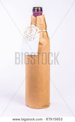 isolated bottle wrapped in paper with white flower and card
