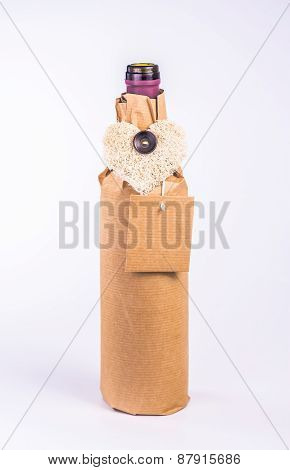 one bottle wrapped in paper with decorative heart and card