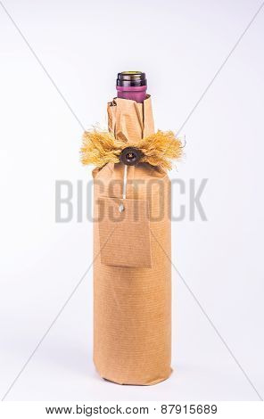 bottle wrapped in paper with decoration and clean card