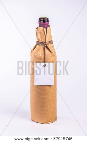 bottle wrapped in paper with white blank card