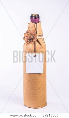 isolated bottle wrapped in paper with flower and card