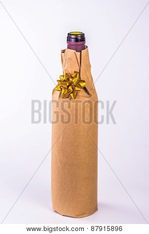 isolated bottle wrapped in paper with golden bow