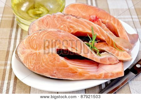 Trout in plate with rosemary and oil on napkin