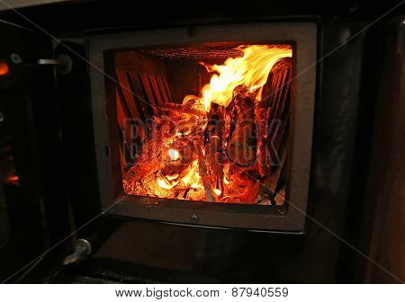 Stove A Wood-burning Stove With Fire Lit In The Old Mountain Home