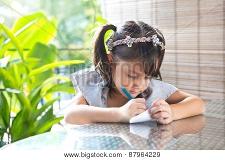 Young girl engross in coloring a drawing.