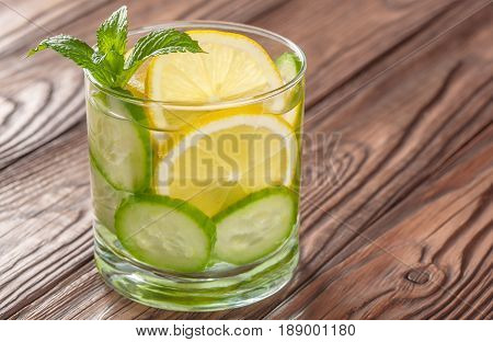 cool drink with lemon and mint on a wooden background