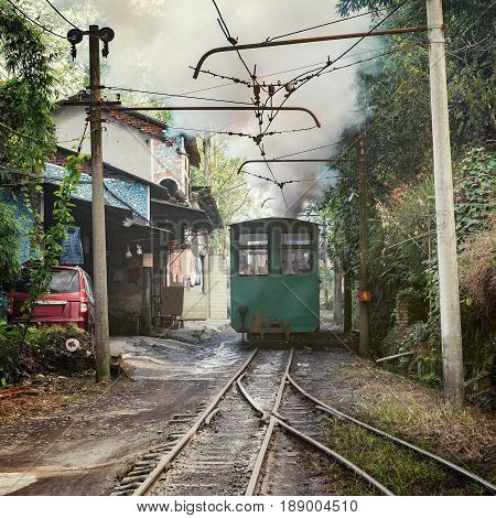 Steam narrow-gauge train moves from Yuejin to Bagou through the village. Jiayang Mining Region. Sichuan province. China