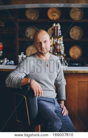 handsome young man sitting at a bar counter