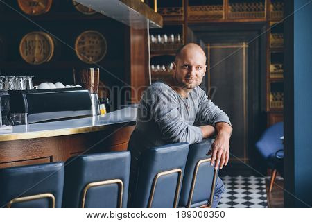 handsome young man sitting at a bar counter