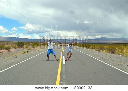 Couple in love dances in the solitude of the Salta puna in the middle of the route