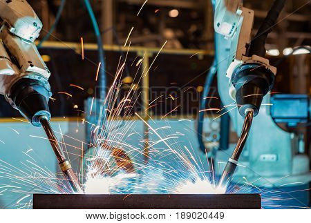 Close up team robots are welding in factory