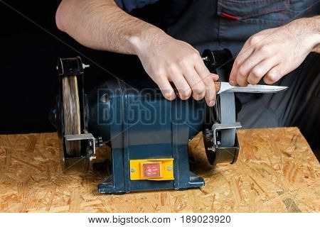 A Man In Working Clothes Hones Professional Sharpening Kitchen Knives