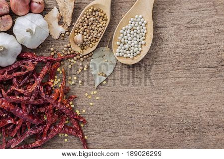 Food ingredients peppercorn and red dry chilli peppers on wooden table asian food cooking concept.