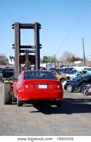 Auto rojo que lleva la carretilla elevadora