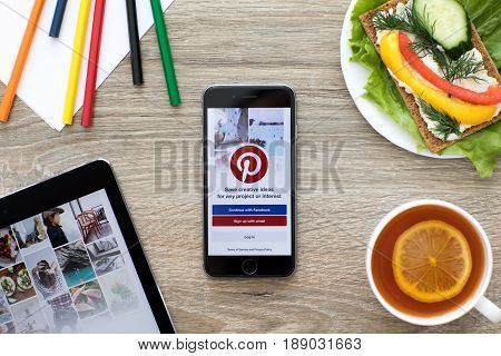 Alushta Russia - May 24 2017: iPad Pro and iPhone with social Internet service Pinterest on the screen. iPad and iPhone was created and developed by the Apple inc.