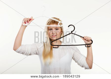 Wardrobe accessories concept. Blonde happy woman holding black clothes hanger having fun.