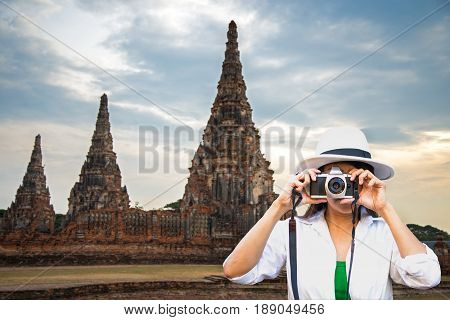 Traveler women covering her face with the camera in the Ayutaya Thailand