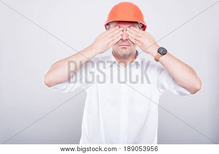 Portrait Of Contractor Wearing Hardhat Covering His Eyes