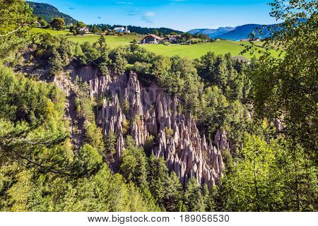 Journey to the magic country. Renon's earth pillars at sunrise. Small mountain village in the Italian Tirol. The concept of ecological tourism