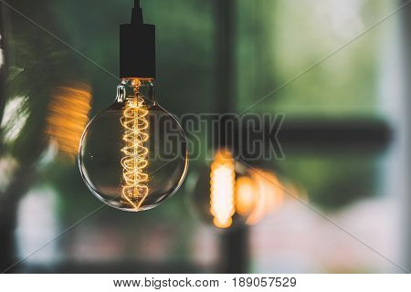 Vintage Edison Light Bulb Hanging With Other Light Bulbs Indoors With Copy Space