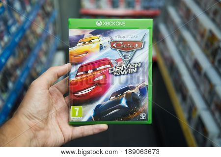 Bratislava, Slovakia, circa april 2017: Man holding Cars 3 Driven to Win videogame on Microsoft XBOX One console in store