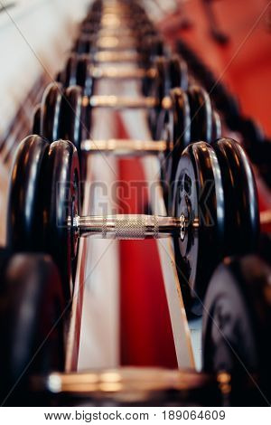 Sports equipment dumbbell rests in a row.  hign contrast and monochrome color tone