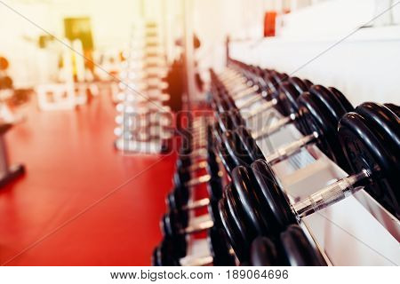 Sports equipment dumbbell rests in a row.  hign contrast and monochrome color tone