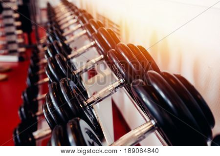 Sports equipment dumbbell rests in a row.  hign contrast and monochrome color tone