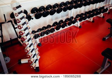 Sports equipment dumbbell rests in a row.  hign contrast and monochrome color tone
